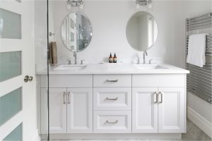 CE-Bath-Gallery4 A bathroom with white cabinets and two sinks and mirrors.