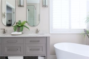 CE-Bath-Gallery5 A bathroom with two sinks and a tub and grey cabinets