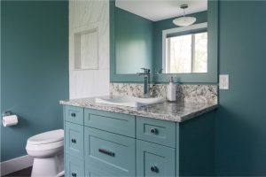 CE-Bath-Gallery6 A bathroom with blue walls and cabinets and a white sink.