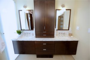 CE-Bath-Gallery9 A bathroom with two sinks and a mirror and wooden cabinets