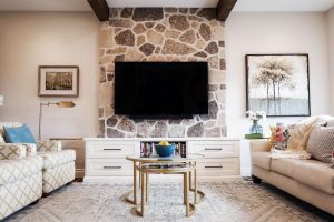 View this gallery image A living room with a stone fireplace and tv.