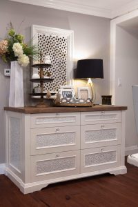 View this gallery image A white dresser in a room with wooden floors.