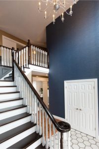 View this gallery image A blue and white stairway with a chandelier.