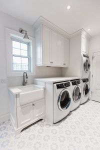 CE-Custom-Gallery18 A white laundry room with custom cabinets and a washer and dryer.