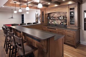 CE-Custom-Gallery3 A home bar with custom wooden cabinets and a bar top.