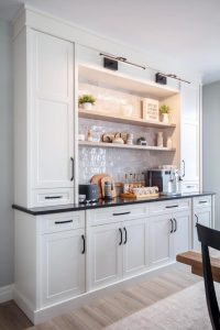 CE-Custom-Gallery8 A white kitchen with wooden custom cabinets and a table.