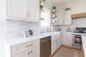 CE-Kitchen-Gallery18 A white kitchen with stainless steel appliances and wood cabinets.