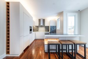 CE-Kitchen-Gallery2 A white kitchen with a wine rack and stools.