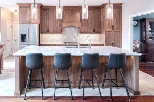 CE-Kitchen-Gallery21 A kitchen with wooden cabinets and a large island and bar stools.