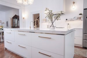 CE-Kitchen-Gallery26 A kitchen with a white island and gold hardware.