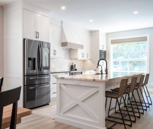 CE-Kitchen-Gallery3 A modern kitchen with a wooden island and stools.